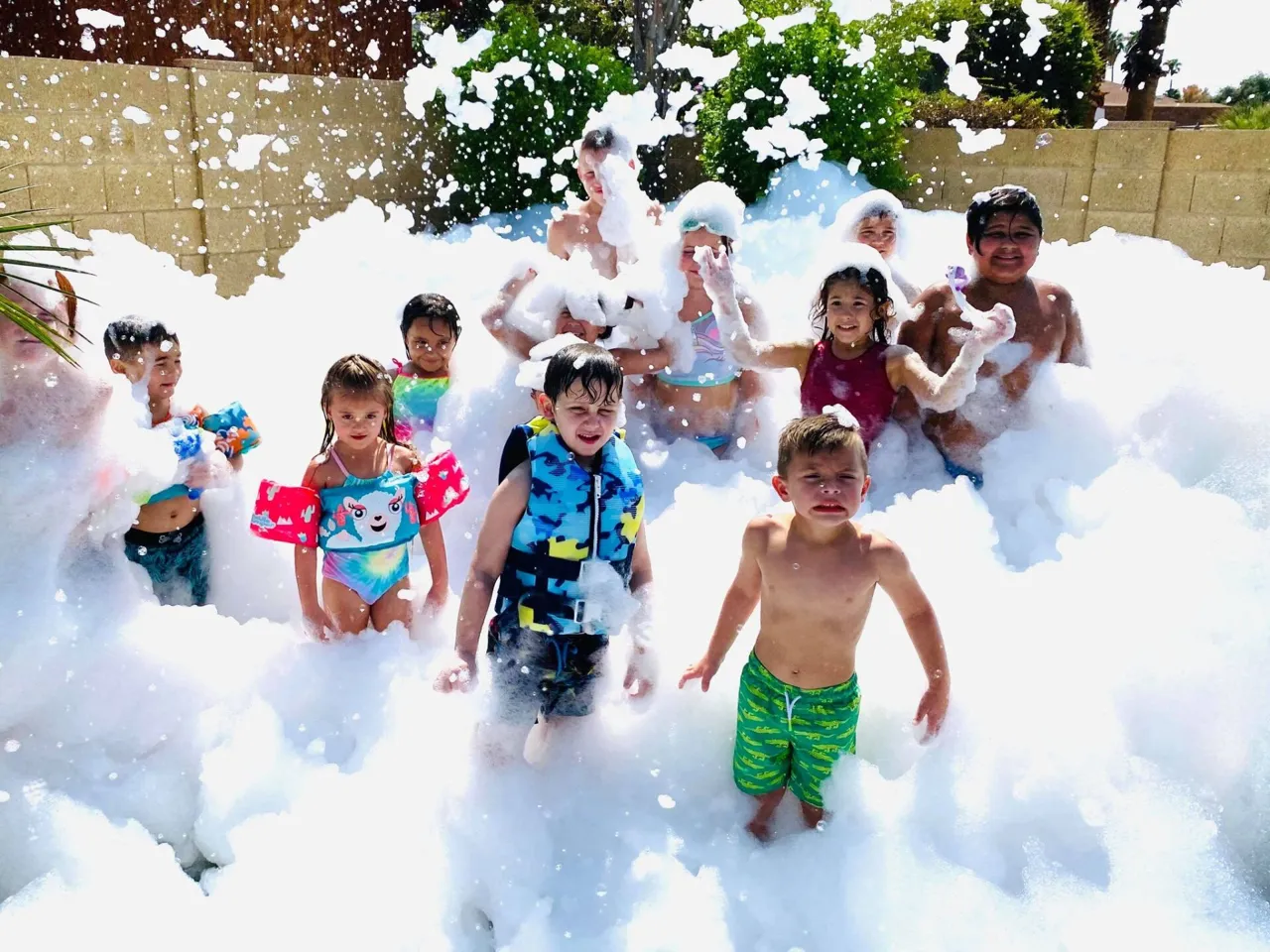 Children playing in foam at a backyard foam party