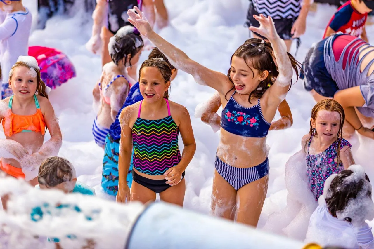 Kids dancing in foam at an Ultimate Foam party in Topeka