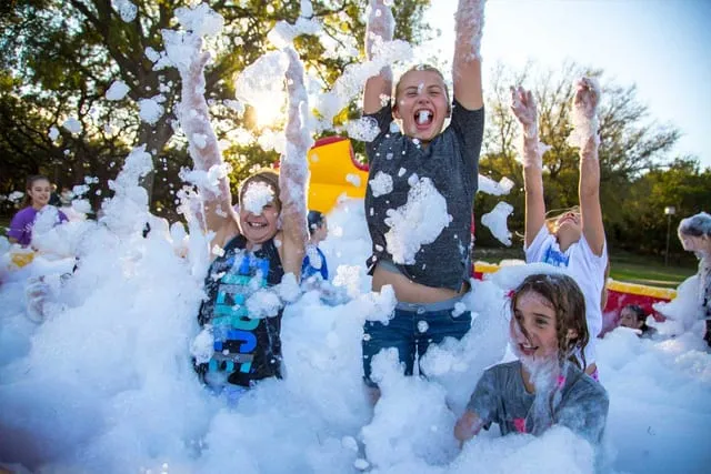 Kids jumping in foam at sunset